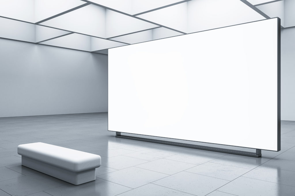 An empty gallery space with a large screen at the centre, ready to showcase captivating digital art.
